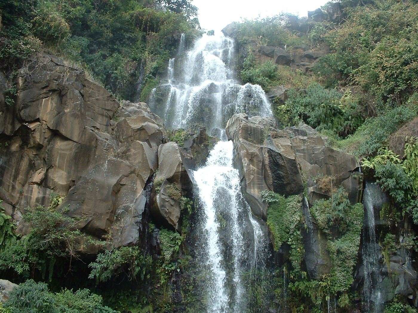 Cascade sur une paroi rocheuse sombre, entourée de végétation, identifiée par l’auteur comme le Bassin Cormoran.