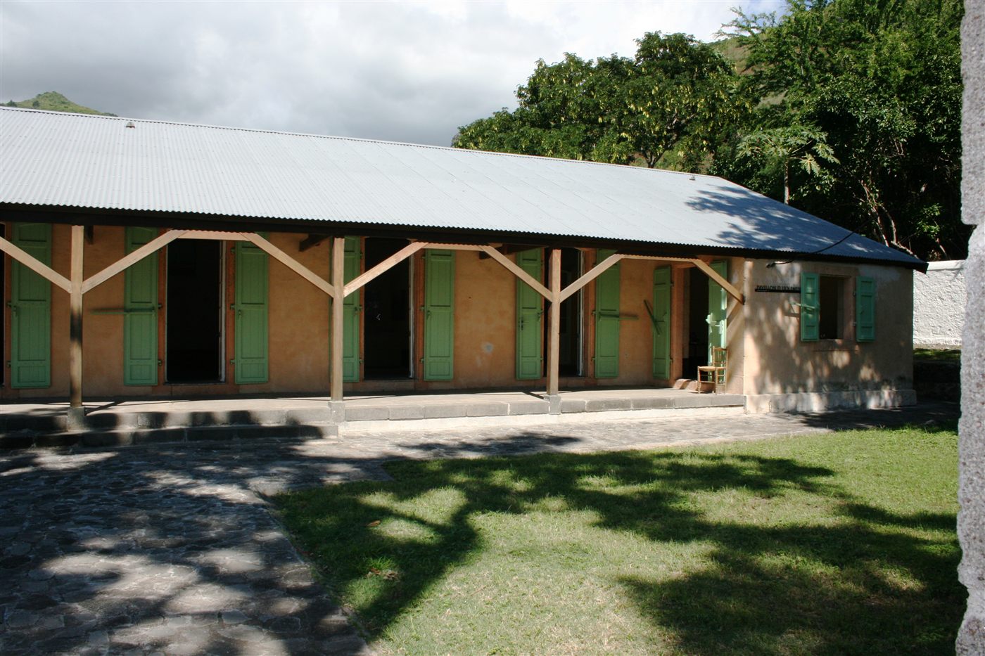 Long bâtiment bas à volets verts et véranda de bois, ancien quartier d’isolement du lazaret de la Grande Chaloupe